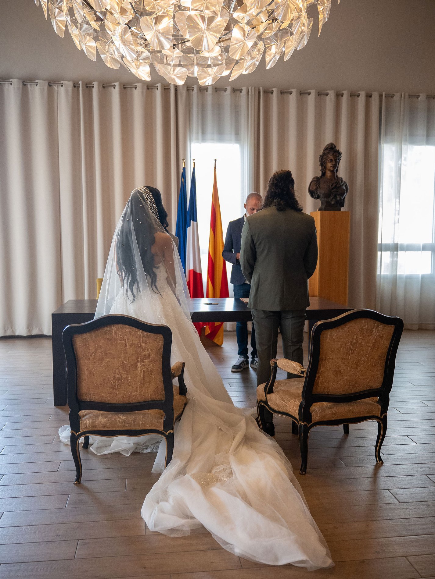 Les mariés de dos pendant la signature des registres, à la mairie