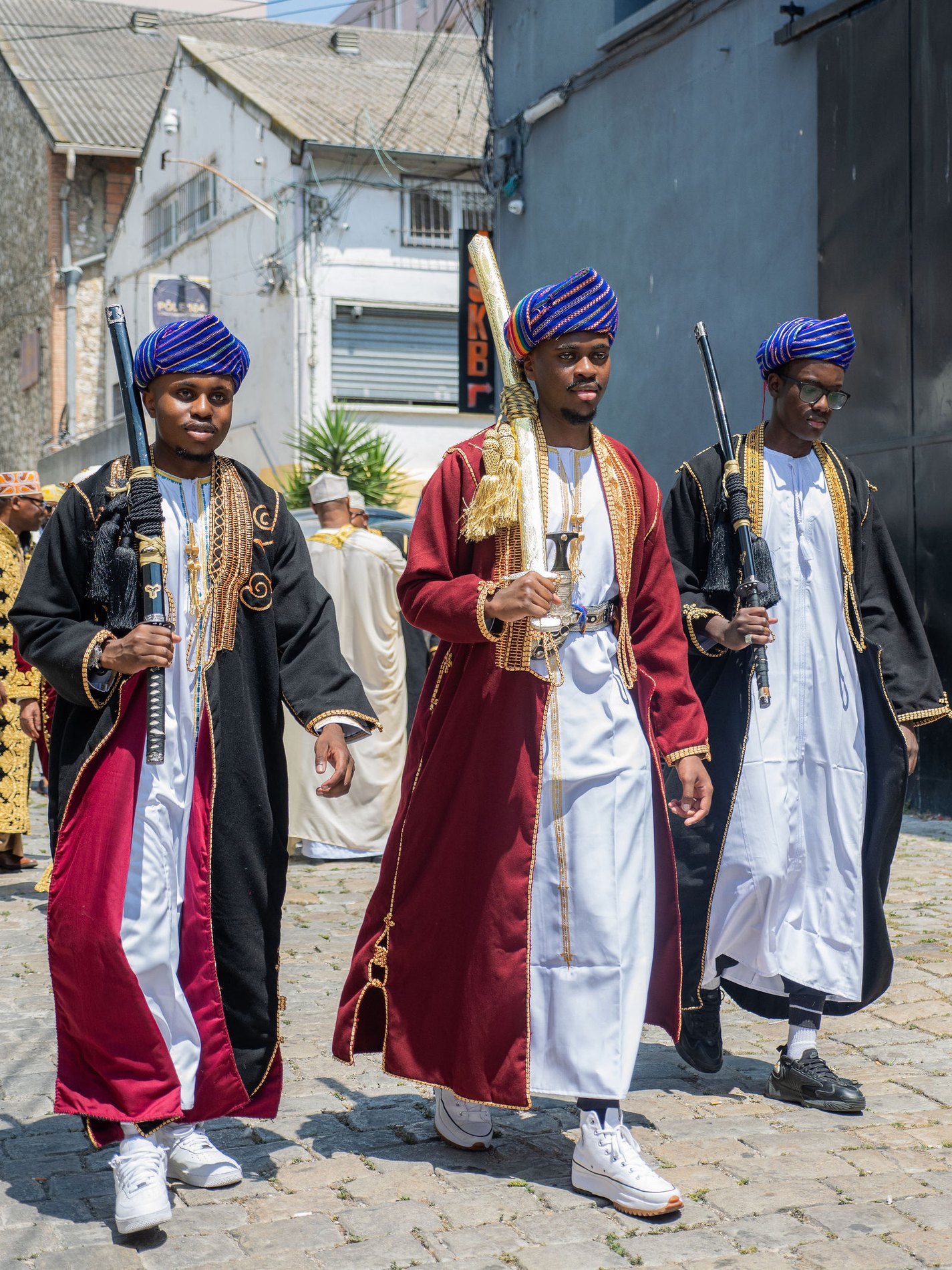 Cortège traditionnel en tenues cérémonielles, sabres à la main