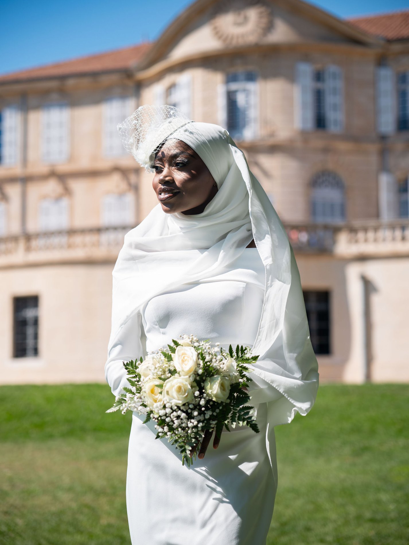 Portrait de la mariée, voilette et bouquet, devant le château