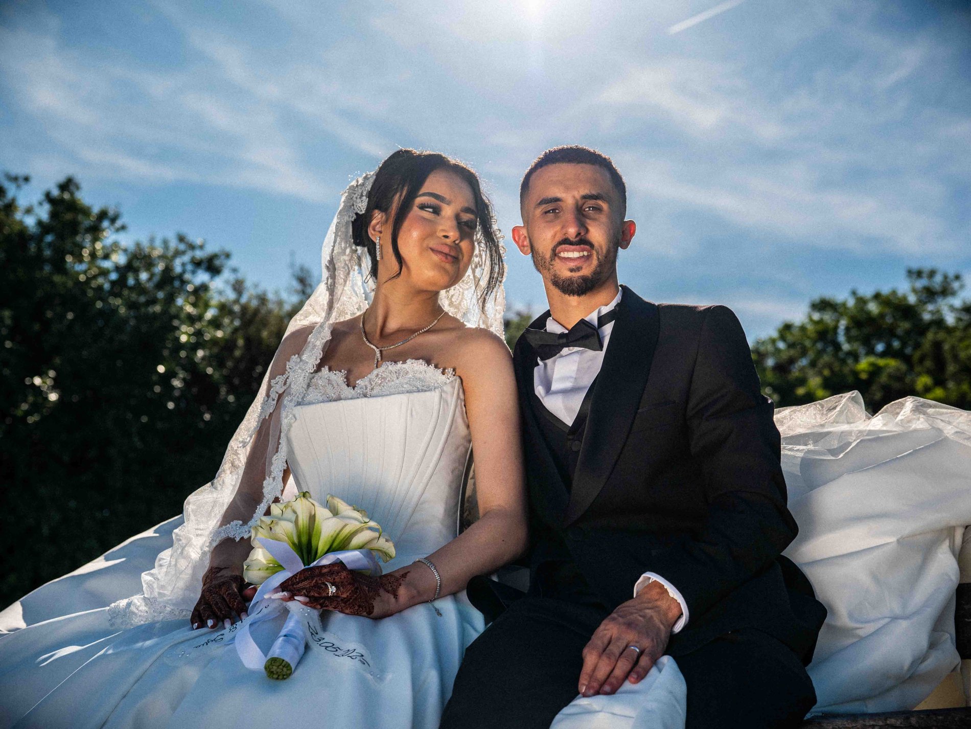 Les mariés assis, souriants, sous les arbres